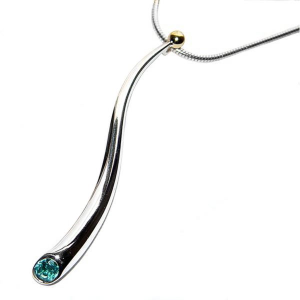 An elegant long curving pendant with 4mm faceted blue topaz on silver snake chain. The solid silver wiggly pendant tapers from 5mm and is approx 50mm long. The sweeping curves enhance the beautiful pure design.