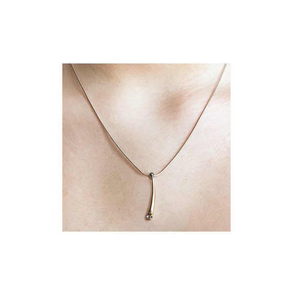 18ct wiggly diamond pendant has a distinct design with elegant simple lines. The solid yellow gold pendant has a brilliant 0.1ct vsfg diamond and 18ct white gold detail. It tapers from 4mm and is approx 25mm long. The pendant usually comes on a silver snake chain.