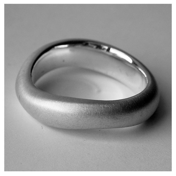 Curved organic silver band. This unusual silver ring has a comfortable rounded band which is flat on the inside. The approximate maximum dimensions are 6mm wide with a depth of 3mm. The ring is plain, understated, and and therefore perfect as an everyday ring for men or women.  