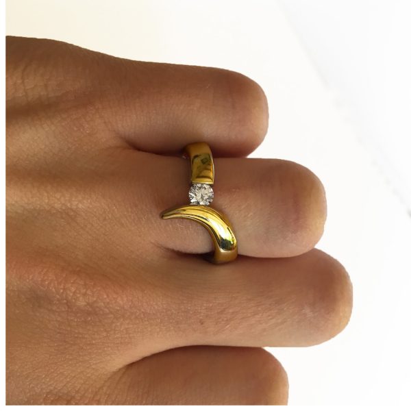 The 18ct gold diamond point ring is elegant yet simple in design. The solid 18ct yellow gold ring has been handforged from 4mm wire and features a tension set 25pt (0.25ct) VSFG Diamond. The solid gold ring is approx 4mm wide and has a depth of 3mm. It is an unusual & stunning diamond ring and makes the perfect engagement ring(in addition there is also a complimentary wedding ring Code C66). The ring is individually handmade to order. Please let us know your ring size when you place your order. Ring sizes H-P (including 1/2 sizes). We have used the UK/AU sizing system, however. If you have a ring size based on EU, US/Canada or any other international sizing system we can convert it. The ring is also available in 18ct white gold or platinum – prices on request. The 18ct gold point ring has a Paul Finch hallmark and conforms to the British hallmarking standard. It is delivered in a Paul Finch Jewellery box.