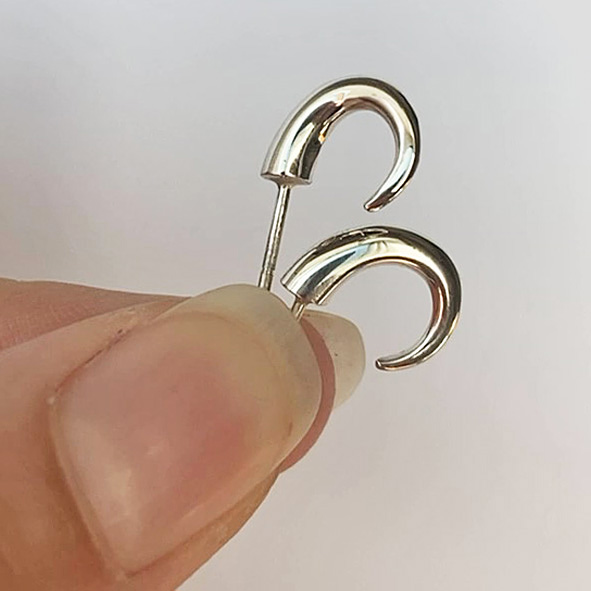 The shape and elegant curl of these small silver wiggly hoop earrings creates a stunning and unusual design.  These solid hoops earrings are practical, comfortable and therefore ideal for everyday wear.  The solid silver earrings taper to a point from 4mm. Approximate maximum dimensions are height 13mm x width 4mm x depth 10mm. Code C41 They have a simple ear post and bell scroll fixing and come in a satin or highly polished finish.