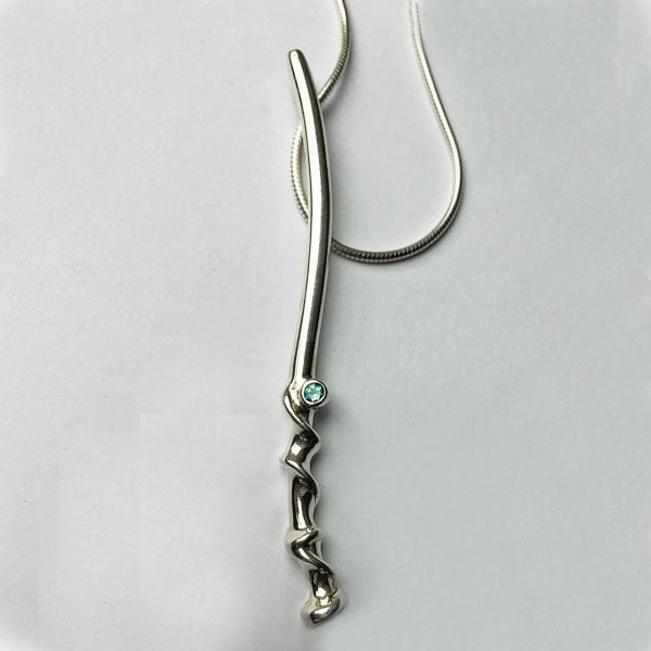 The long twist vine pendant is elegant and unusual. The delicate silver detail is enhanced with a sparkling 2mm blue topaz and contrasting polished finish.  The pendant is approximately 62mm long and has a width of 3mm. The pendant is available with a variety of gemstones and comes on a silver snake chain