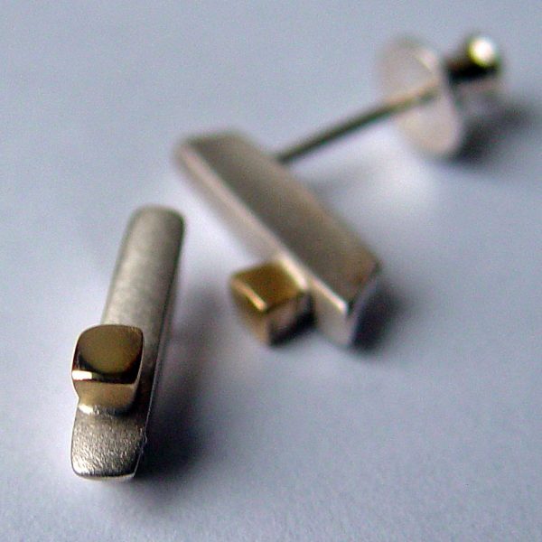 Silver 18ct ingot earrings. These unusual silver drop stud earrings have contrasting 18ct gold detail.  The earrings have approximate maximum dimensions of 15mm with a width of 3mm and depth of 4mm.  They have a simple ear post and bell scroll fixing and are featured in a satin finish with polished 18ct yellow gold detail. You can clean the earrings with silver dip, rinse in warm soapy water, dry thoroughly. For polished finish use silver polishing cloth/ and or silver dip. The silver 18ct ingot earrings are delivered in a Paul Finch Jewellery gift box. FREE Delivery The parcel will be sent out using secure Colissimo International tracked and signed for service and will require a signature on receipt. The earrings will be despatched within 1-3 working days.