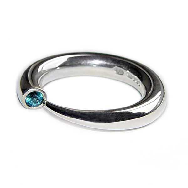 This solid tapering silver wiggly ring has a comfortable rounded band. The ring tapers to a point from 4mm and features a 3mm blue topaz. The ring is one of the original design in the wiggly collection and is a timeless classic.