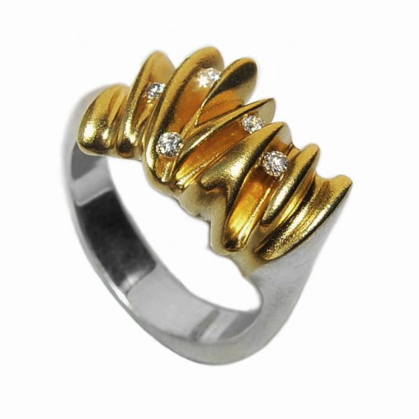 The 5 diamond sculptural shell ring is a stunning new addition to the collection. It is an unusual, elegant silver ring which has 5 brilliant vsfg diamonds (2x0.02ct, 3x0.03ct) set within golden waves. The solid silver undulating band has contrasting 22ct gold plating. Approximate maximum dimensions are 5mm at the back narrowing to 4mm and  12mm at the widest point of the top.  The unusual sculptural ring is a perfect eternity ring or a statement ring suitable for every occasion.