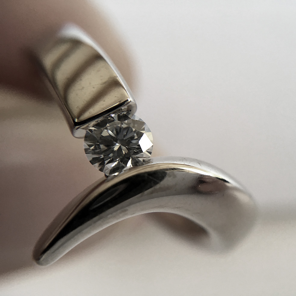 The 18ct diamond point ring is elegant yet simple in design. The solid 18ct white gold ring has been handforged from 4mm wire and features a tension set 25pt (0.25ct) VSFG Diamond. The solid gold ring is approx 4mm wide and has a depth of 3mm. It is unusual and stunning and makes the perfect engagement ring (in addition there is also a complimentary wedding ring Code C66). The ring is individually handmade to order. Please let us know your ring size when you place your order. Ring sizes H-P (including 1/2 sizes). We have used the UK/AU sizing system, however. If you have a ring size based on EU, US/Canada or any other international sizing system it can be converted. The ring is also available in 18ct yellow gold or platinum – prices on request. The 18ct gold point ring has a Paul Finch hallmark and conforms to the British hallmarking standard. It is delivered in a Paul Finch jewellery box.