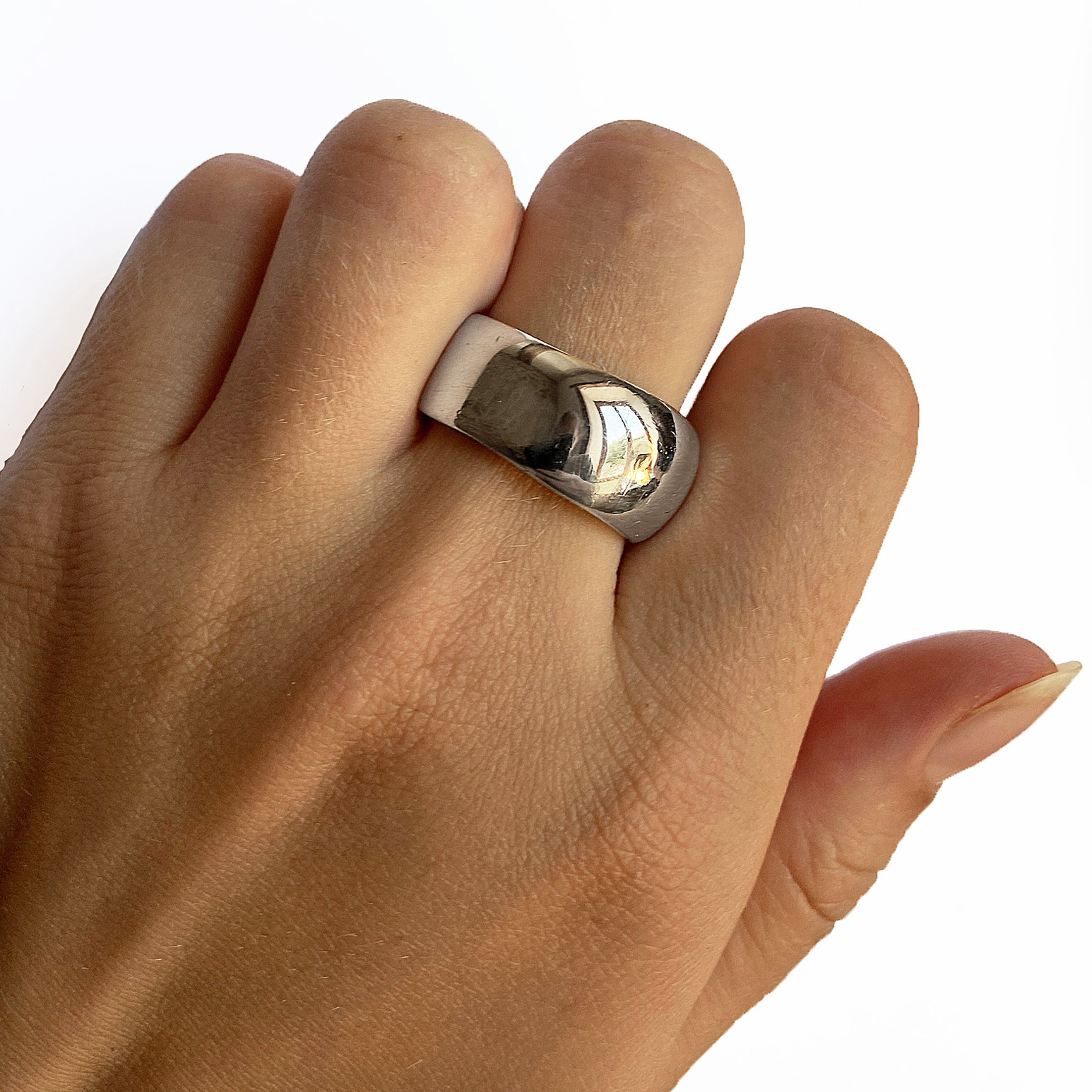 An unusual organic silver band. The smooth solid undulating band is approx 11mm at the widest point and has a varying depth of 2-3mm. It is practical and comfortable to wear. The ring is individually handmade to order and is available in a wide range of sizes including 1/2 sizes. Please let us know your ring size when you place your order. We use the UK/AU sizing system, however. If you have a ring size based on EU, US/Canada or any other international sizing system we can convert it. If you would like the ring in 18ct gold, please contact us for more details. The organic silver band has a Paul Finch hallmark and conforms to the British hallmarking standard. It comes in a branded jewellery box.