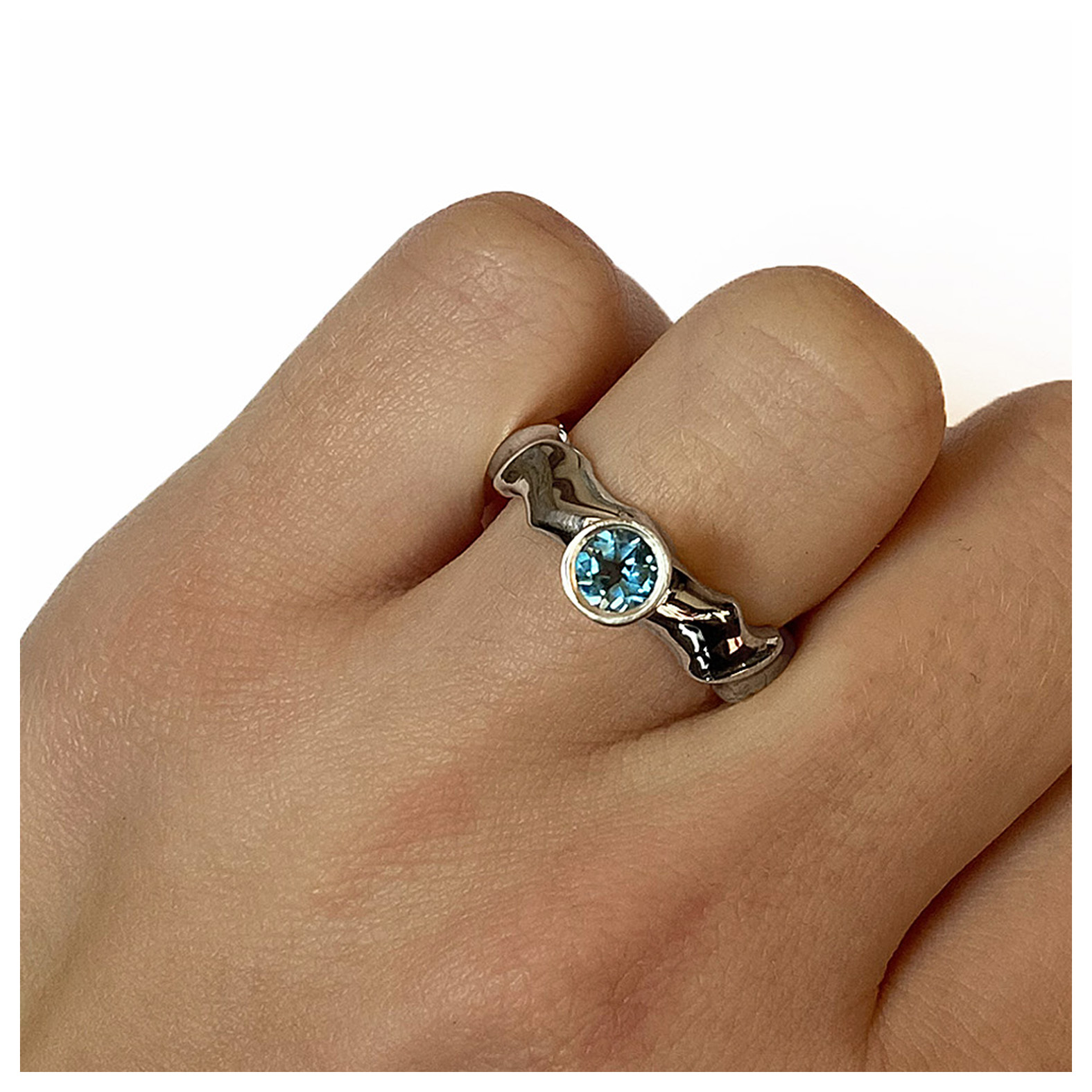 The silver gemset vine ring is striking and elegant. The centre piece of the ring is a sparkling 5mm blue topaz which compliments the delicate silver detailing of the band. The undulating band has a width of approximately 6mm at the widest point and a depth of approximately 2.5mm. The main picture shows the ring with blue topaz in a polished finish. If you would like an alternative gemstone our main choice includes blue topaz,amethyst, garnet, citrine, peridot, iolite. The ring is also available in a satin finish. The silver gemset vine ring is handmade to order to your specific finger size. Please let us know your ring size when you place your order. We have used the UK/AU sizing system, however. If you have a ring size based on EU, US/Canada or any other international sizing system we can convert it. The ring has a Paul Finch hallmark and conforms to the British hallmarking standard. It is delivered in a Paul Finch jewellery box. Cleaning instructions For satin finish use silver dip, rinse in warm soapy water, dry thoroughly. For polished finish use silver polishing cloth/ and or silver dip. FREE Delivery The parcel will be sent out using secure Colissimo International tracked and signed for service and will require a signature on receipt. Usually despatched within 2-5 working days
